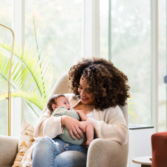 Eine junge Mutter hält ihr Baby im Arm und genießt die erste Zeit nach der Geburt mit finanzieller Unterstützung durch Mutterschaftsgeld.