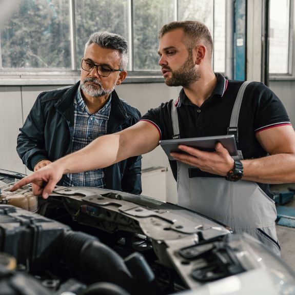 Mechaniker untersuchen Auto in der Werkstatt.