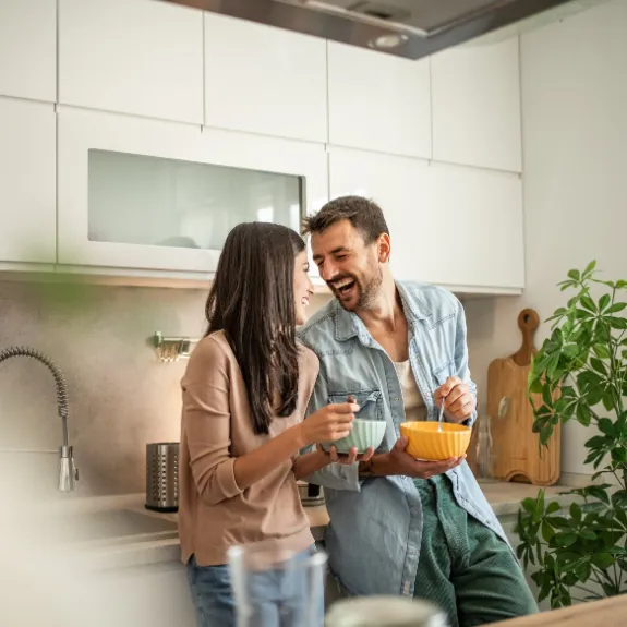 Eine Frau und ein Mann genießen ihr Frühstück in der Wohnung.