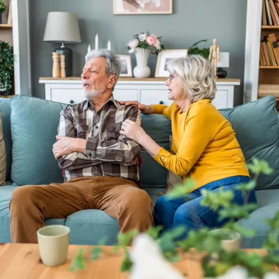 Ehemann wendet sich mit verschränkten Armen von seiner Frau ab.