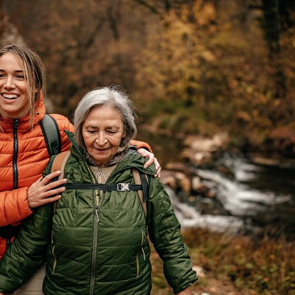 Eine junge Frau geht mit ihrer Großmutter wandern.