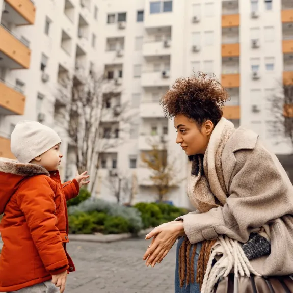  Eine Mutter sitzt auf der Bank und unterhält sich mit ihrem Kind. Ein Beispiel für die Aufsichtspflicht bei Kindern.