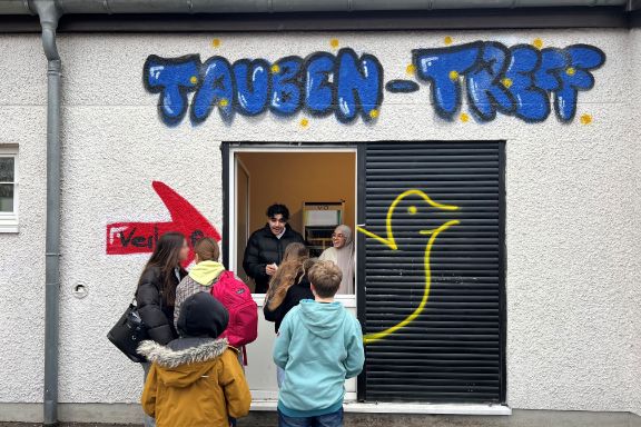 Schülerinne und Schüler der Helene-Lange Schule in Wiesbaden stehen auf dem Schulhof vor einem selbst gegründeten Kiosk