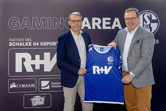 R+V-Vertriebsvorstand Jens Hasselbächer und Peter Knäbel, Sportvorstand des FC Schalke 04, präsentieren nach der Vertragsverlängerung das aktuelle Esport-Trikot.