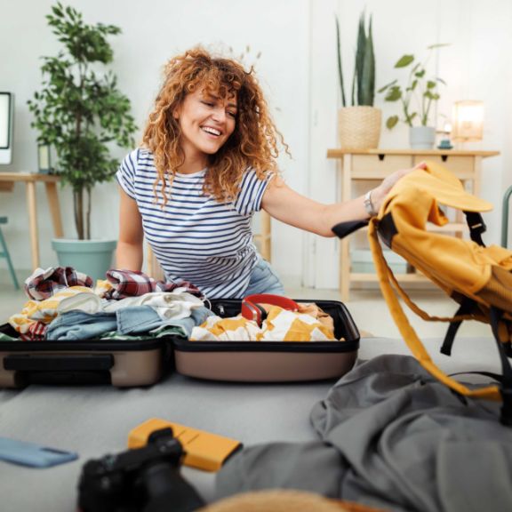 Junge Frau packt ihren Koffer für ihr Auslandssemester.