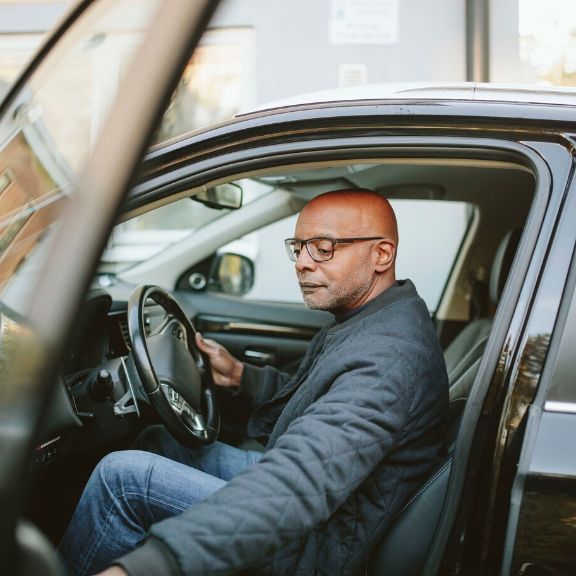 Mann begutachtet Innenraum eines Autos.