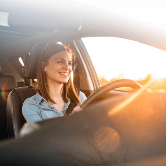 Die 5 günstigsten Gasautos Junge Frau fährt Auto.