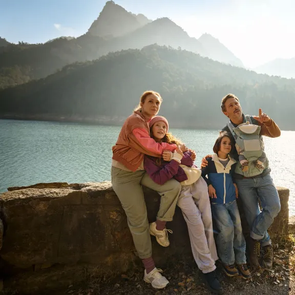 Eine Familie genießt ihren Urlaub in den Bergen, abgesichert durch eine Auslandsreisekrankenversicherung.