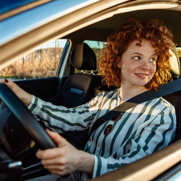 Welche Kfz-Versicherung und Beitragsprozente gibt es für Fahranfänger? Junge Frau im Auto