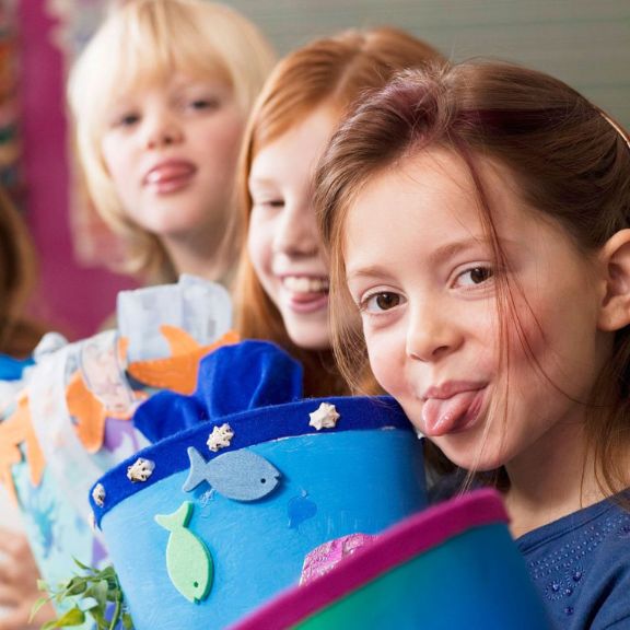 Kinder mit Schultüten. Alle strecken die Zunge heraus.