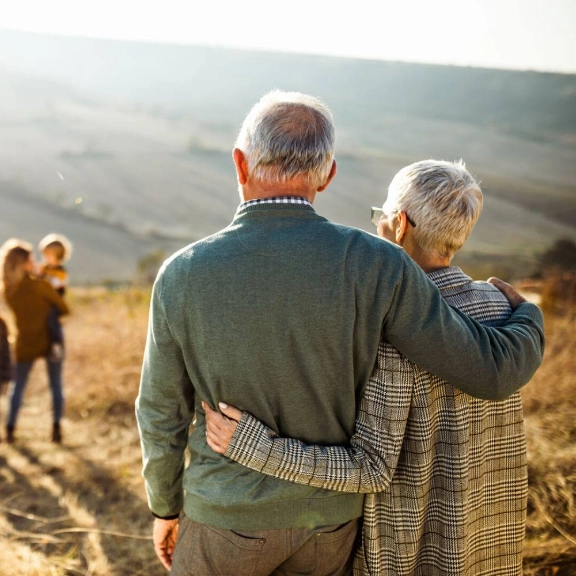  Ein älteres Paar, welches auf seine weggehende Familie/Jüngere Generation schaut.