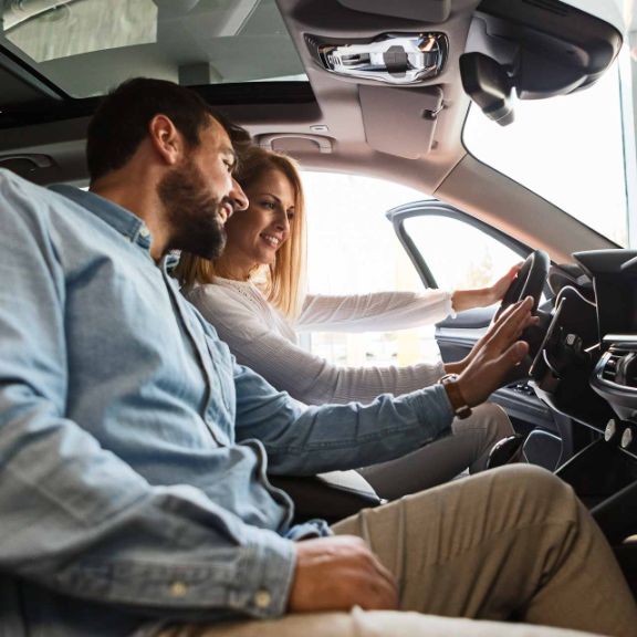 Entscheidungskriterien beim Autokauf Junges Paar kauft Neuwagen