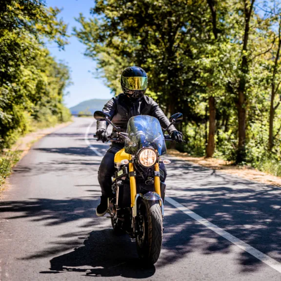 Motorradfahrer fährt unbeschwert auf seinem Leichtkraftrad dank der 125er-Versicherung.