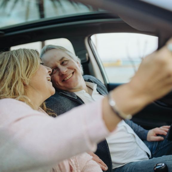 Glückliches Seniorenpaar unterwegs im Auto.