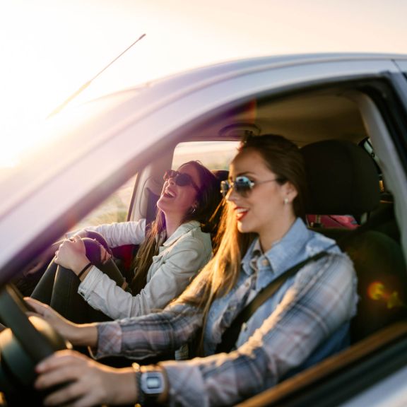 Zwei junge Frauen unterwegs im Auto.