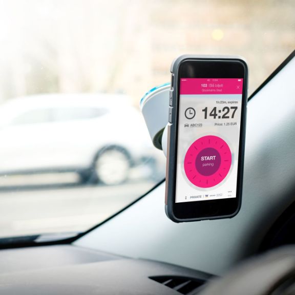Handyhalterung im Auto mit Easypark-App auf dem Bildschirm.