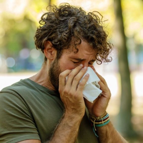 Mann mit Pollenallergie niest