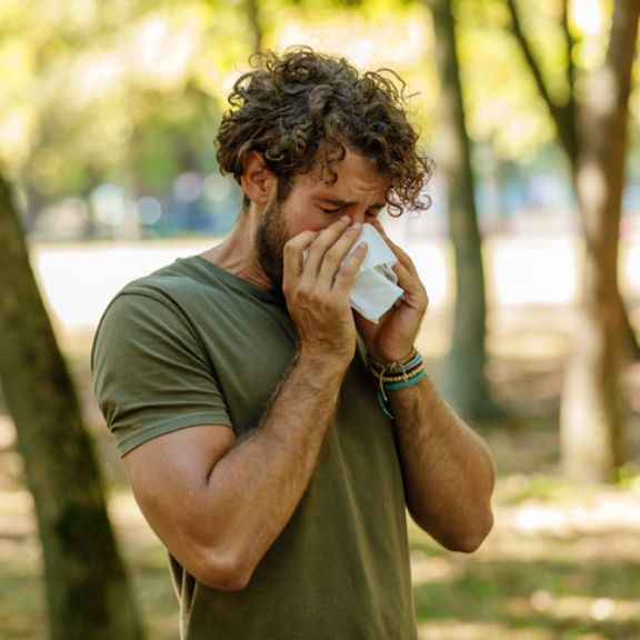 Mann mit Pollenallergie niest