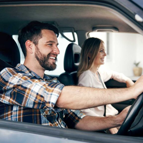 Zwei glückliche Personen im Auto.