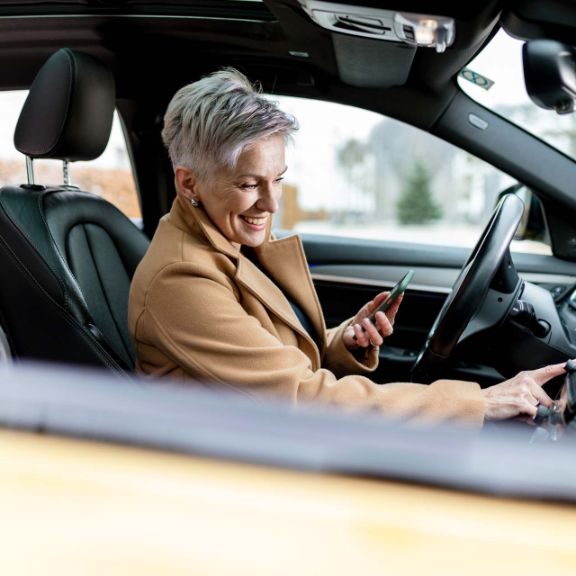 Frau bedient das Infotainment-System im Auto.