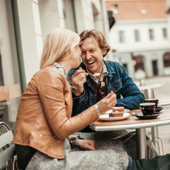 Frau und Mann genießen Kuchen in einem Cafe.