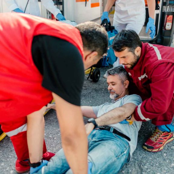 Erste Hilfe – Stabile Seitenlage Sanitätsteam hilft verletzter Person.