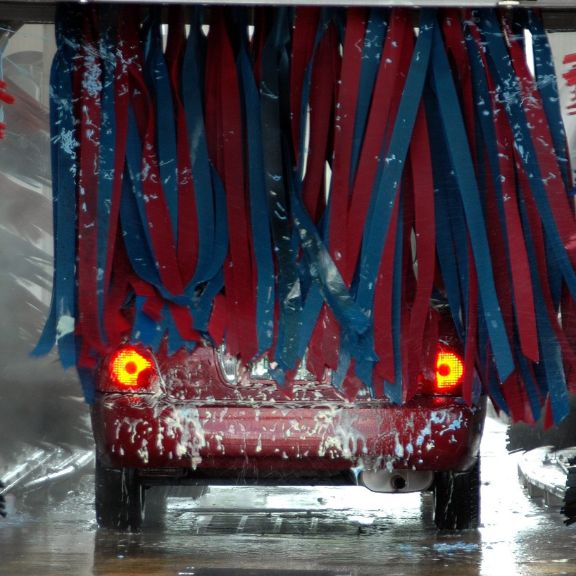 Beste Waschanlagen Ein rotes Auto in der Autowaschanlage.