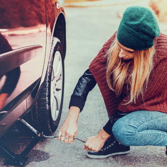 Frau wechselt ihre Autoreifen