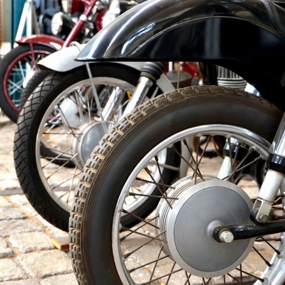 Oldtimer Motorräder stehen vor einem Museum