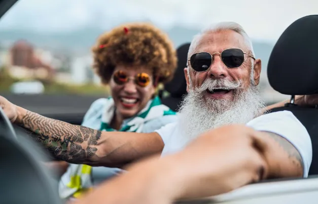 Ein Mann und eine Frau freuen sich in Berlin über eine zuverlässige Kfz-Versicherung.
