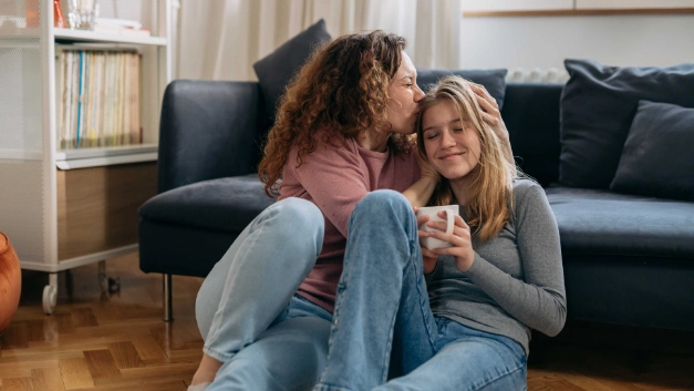 Eine Mutter umarmt ihre Tochter, die gerade in ihre erste eigene Wohnung gezogen ist.