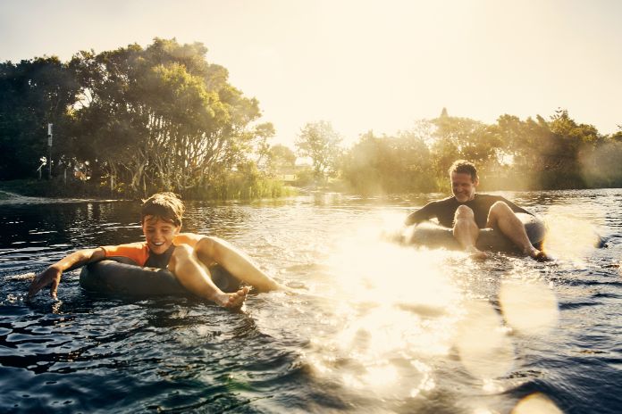 Vater und Sohn im Fluss auf Schwimmreifen.