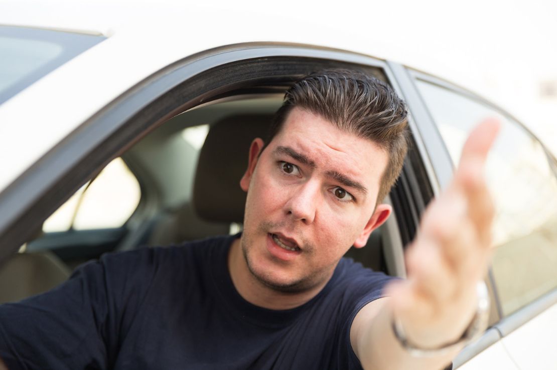 Gestresster Autofahrer diskutiert durch das offenen Fenster