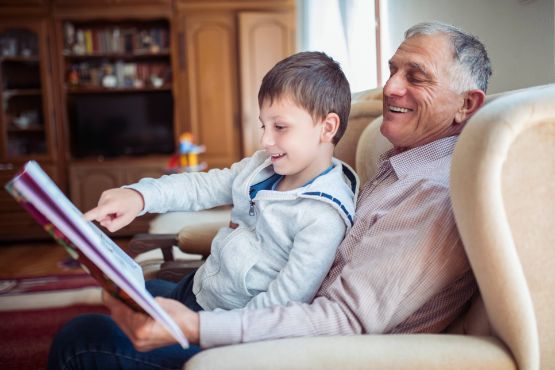 Alter Mann zeigt kleinem Junge ein Fotoalbum.
