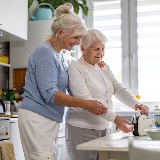 Häusliche Pflege: Eine pflegende Angehörige kümmert sich um eine pflegebedürftige Seniorin.