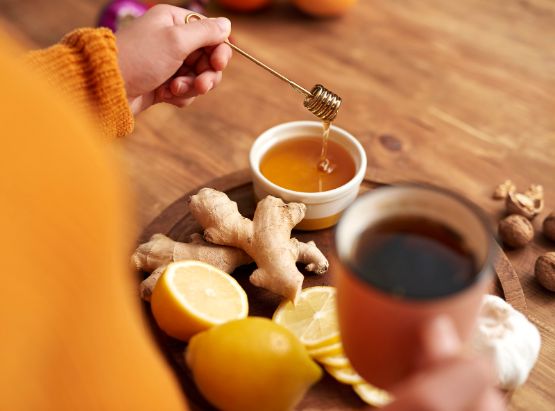 Teetasse mit Honig und heißer Zitrone und Ingwer.