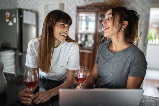 zwei Frauen trinken zusammen Rotwein
