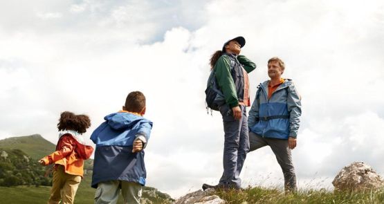 Eltern freuen sich mit ihren Kindern in der Natur, weil sie mit der AnsparKombi finanziell vorsorgen konnten.
