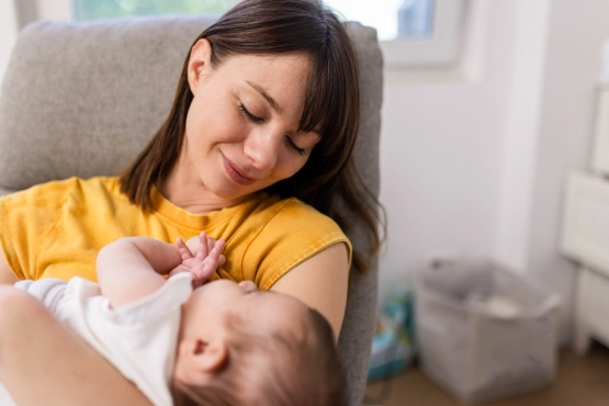Eine Frau hat ein kleines Baby auf dem Arm.