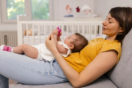 Eine Frau mit kleinem Baby auf dem Schoß-