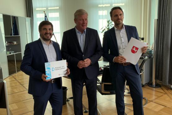 Tim Baumeister (R+V/MO14), Wirtschaftsminister Bernd Althusmann und Matthias Jung (R+V/MO14) bei der Übergabe des Förderbescheids für das Projekt KRAVAG Truck Parking