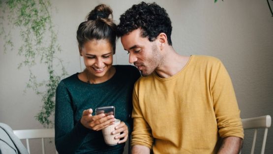 Ein Paar schaut gemeinsam auf ein Smartphone.