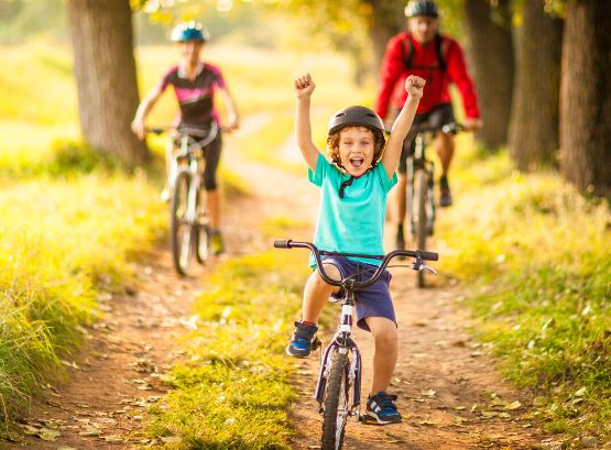 Eine Familie fährt im Wald Fahrrad.