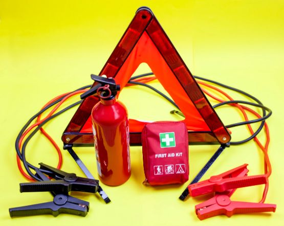 Notfall-Pannen-Kit für das Auto mit Warndreieck, Verbandskasten, Starthilfekabel und Feuerlöscher.