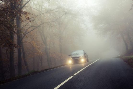 Auto fährt durch den Nebel.