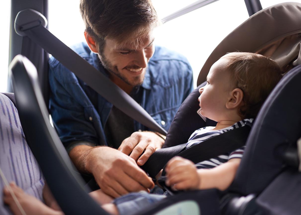 Vater schnallt sein Baby an