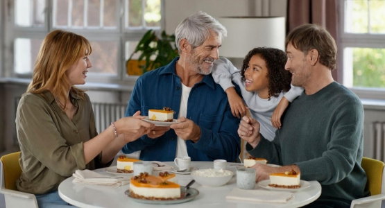 Familie sitze am Kaffetisch und isst Torte.