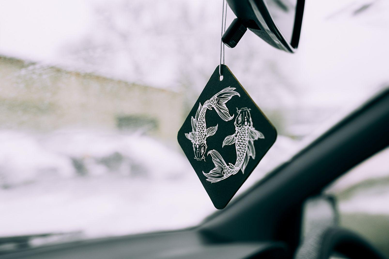 Lufterfrischer im Auto in Form einer Zeichnung des Tierkreiszeichens Fische